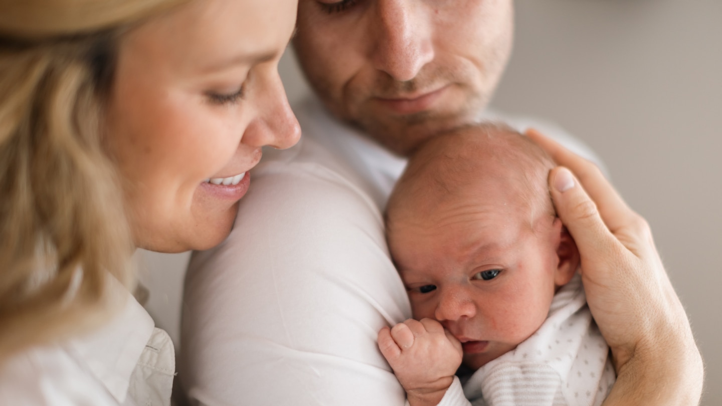 mutter-und-vater-kuscheln-mit-baby