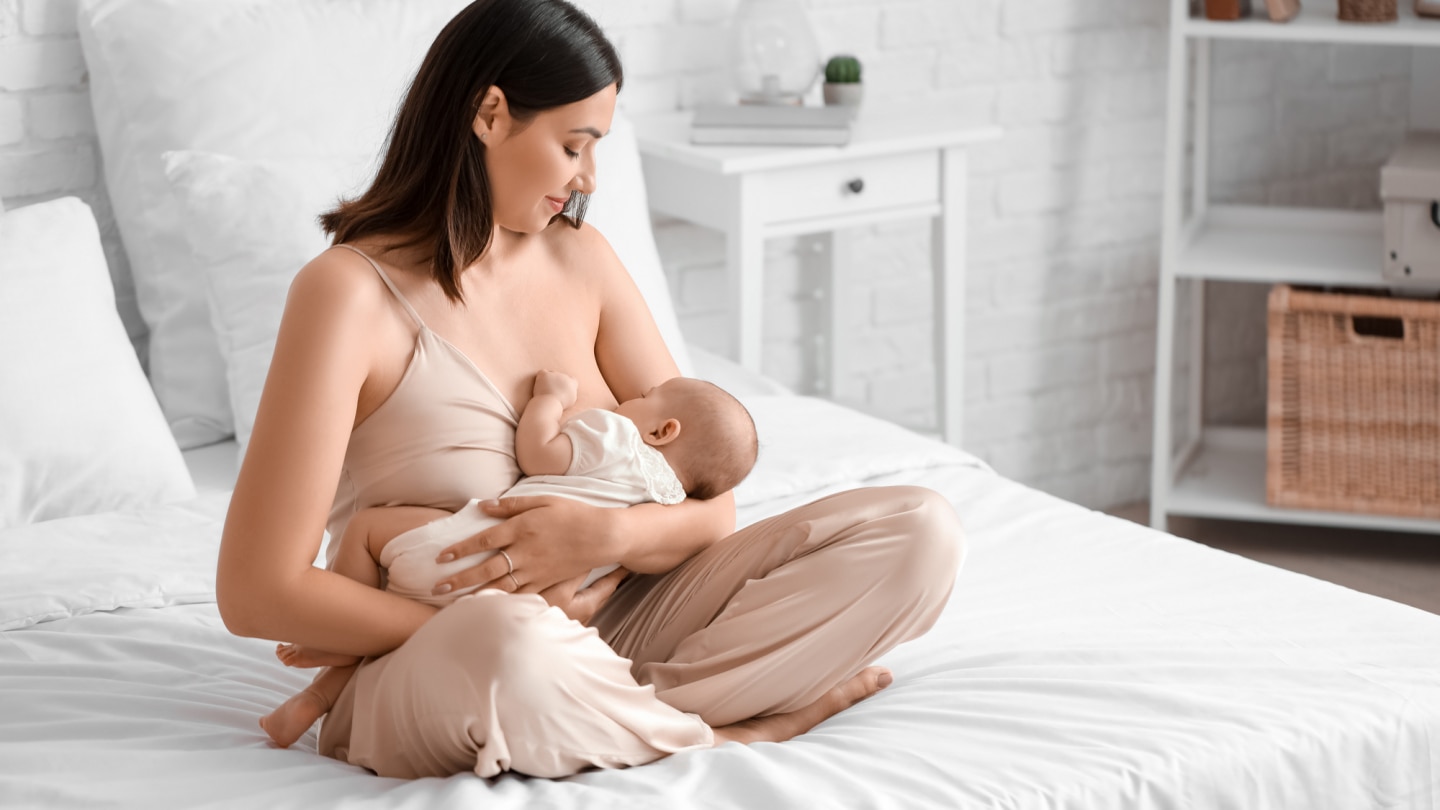 mutter-stillt-baby-im-bett