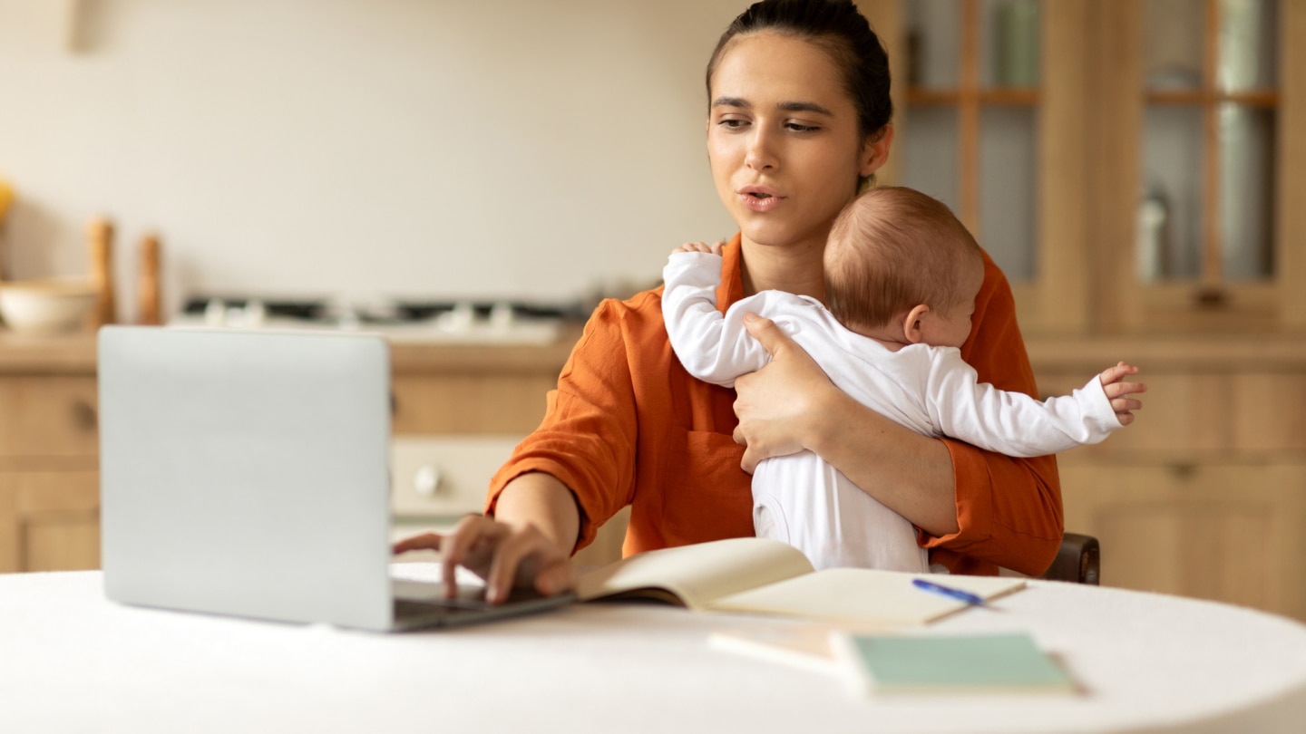 mutter-am-laptop-mit-baby-im-arm
