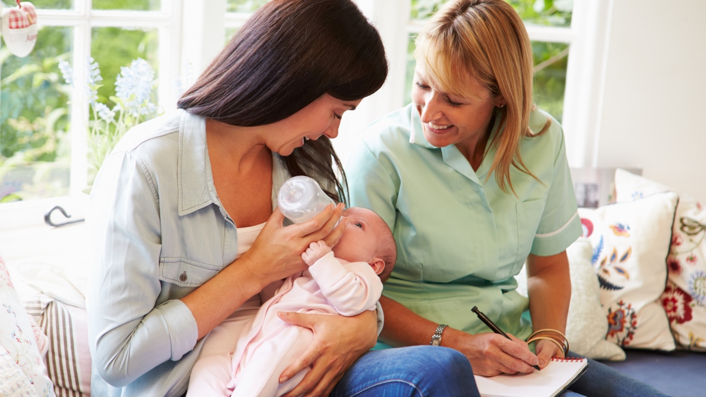 mutter-stillt-baby-in anwesenheit-von-hebamme