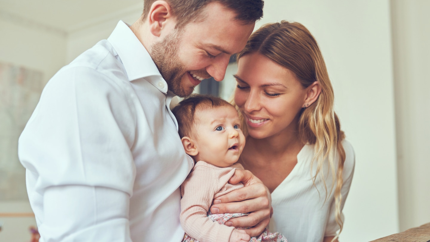 eltern mit ihrem baby im arm