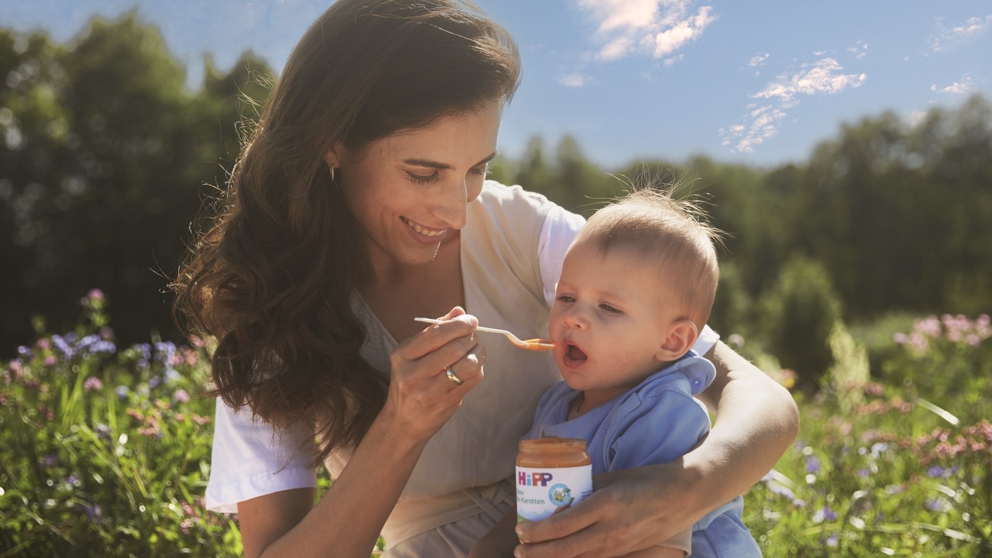 mama mit baby im gras