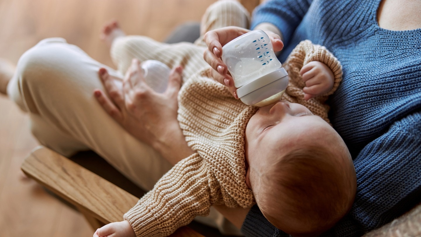 baby bekommt ein flaeschchen von ihrer mama