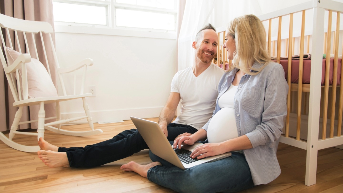 schwangere und partner vor babybett