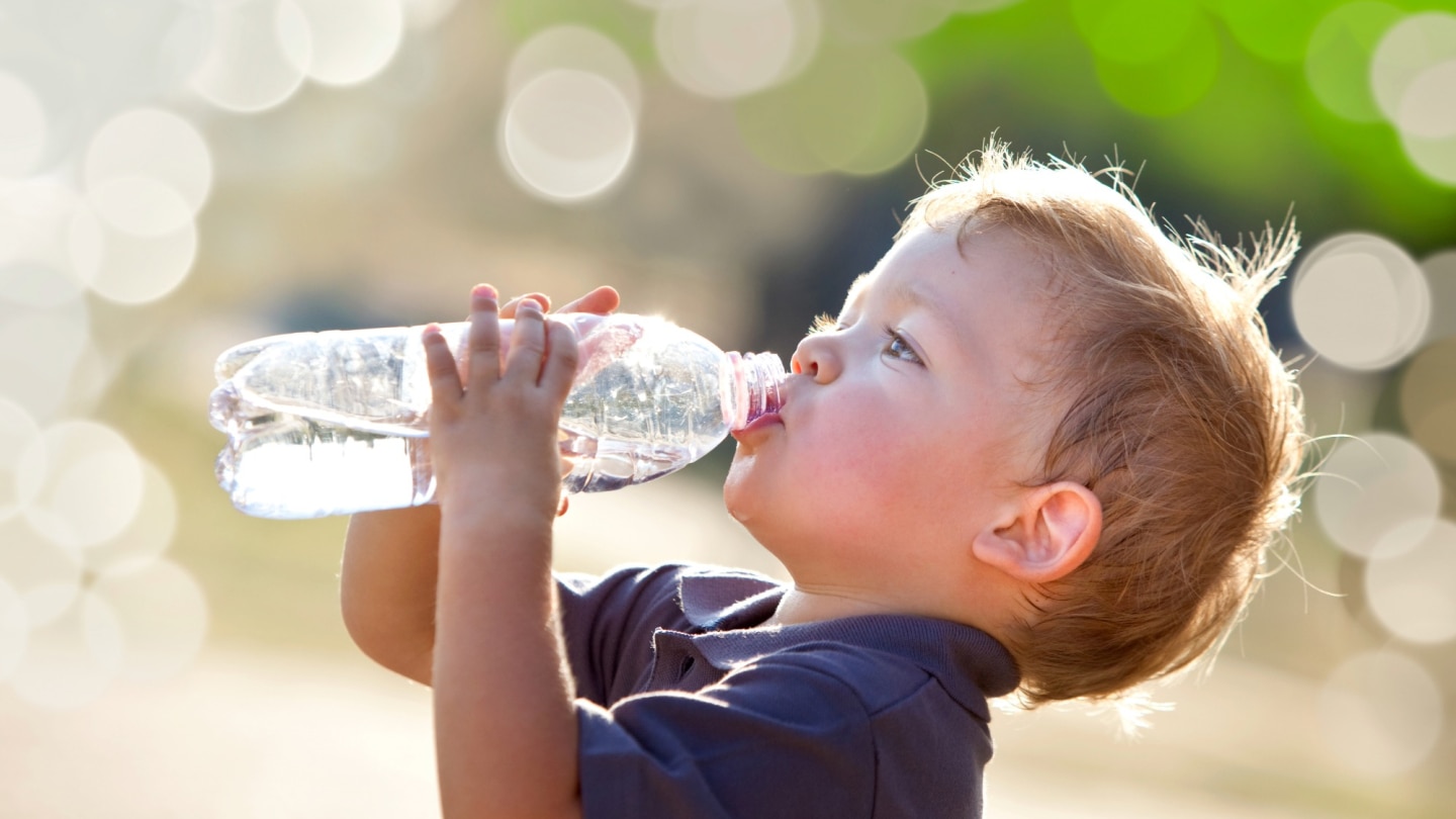 junge trinkt wasser aus einer flasche