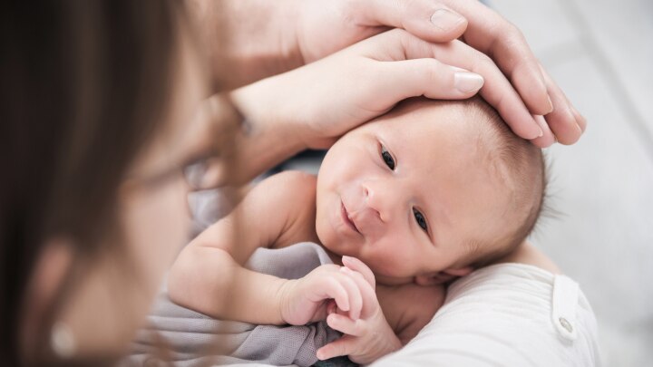 Baby mit Haenden auf dem Kopf