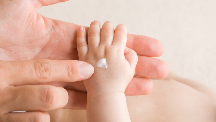 creme auf babyhand