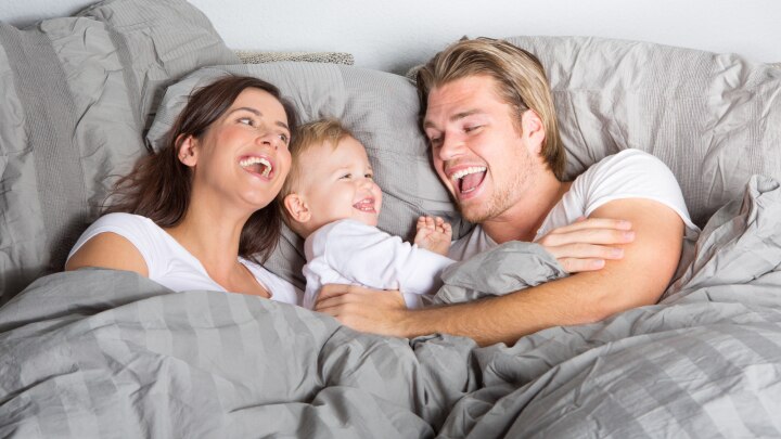 paar und baby im bett