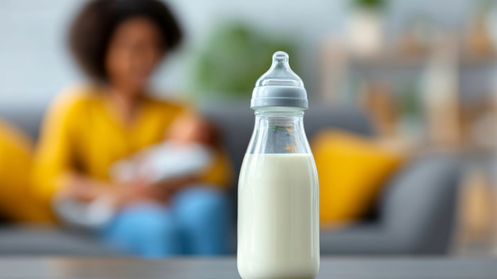 mama und baby hinten auf dem sofa und flasche im vordergrund