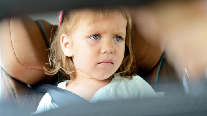maedchen sitzt im auto und ihr ist uebel