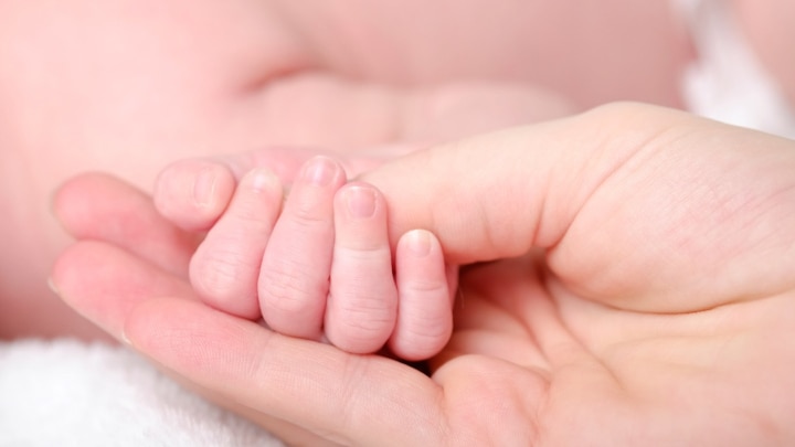 babyhaendchen in mamas hand