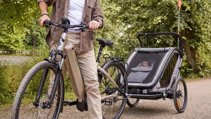 vater mit fahrradanhänger und kind