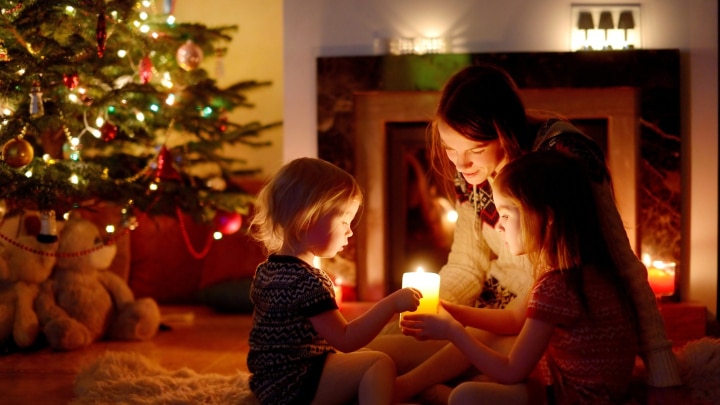 mama und zwei mädchen vor dem weihnachtsbaum