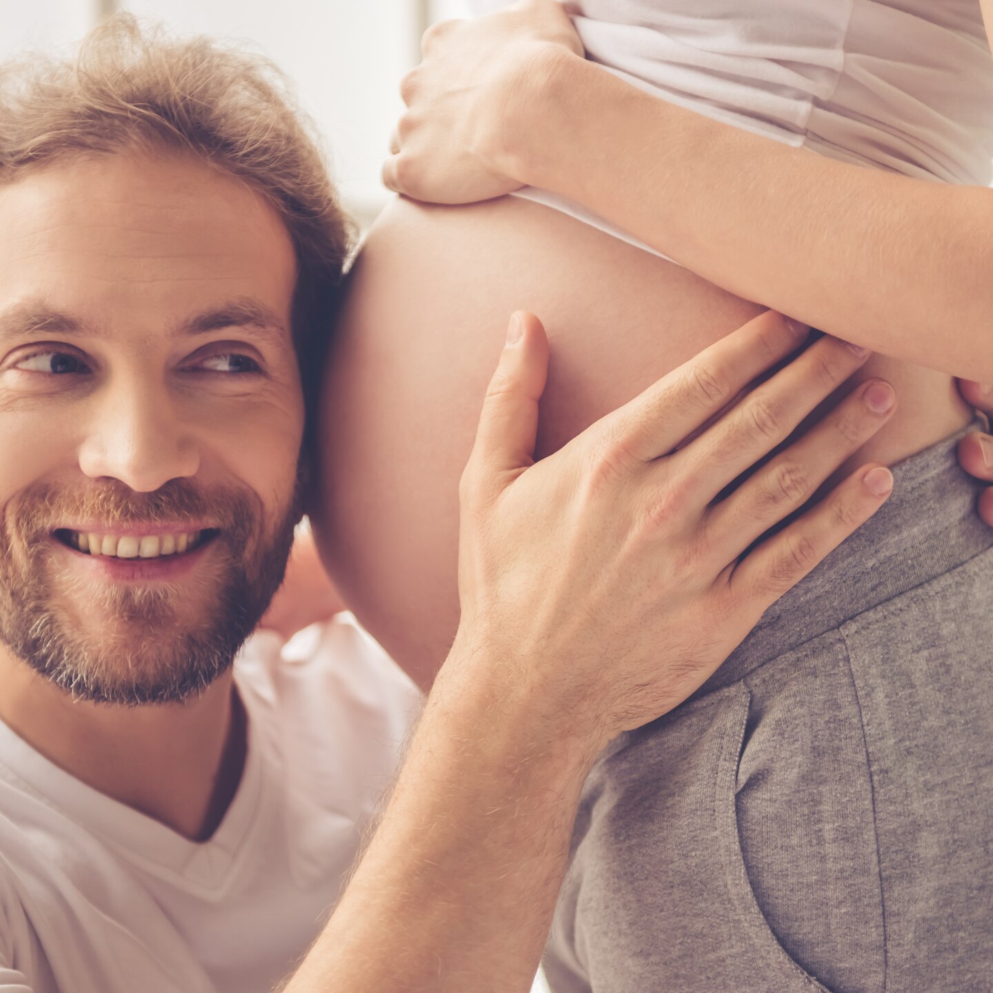 Vater hört Babybauch an