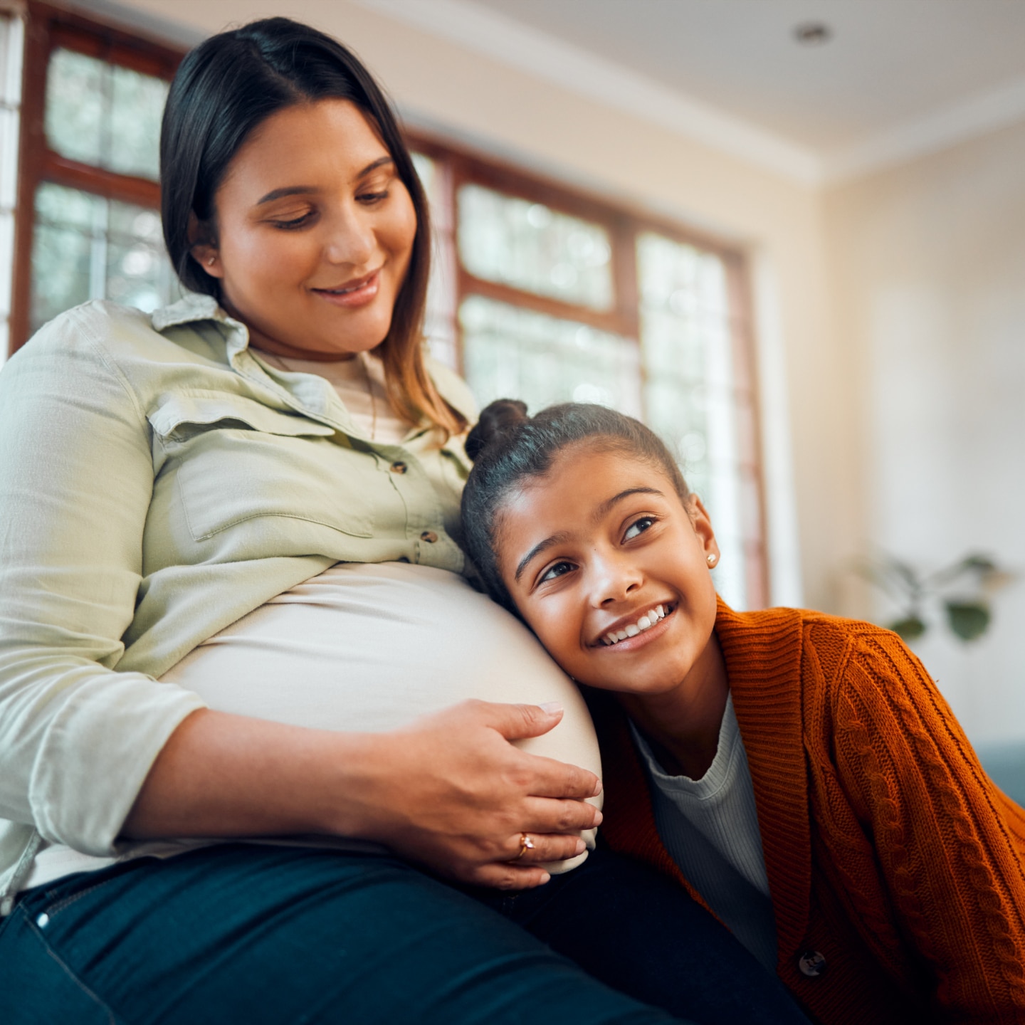 Kind hört Babybauch an