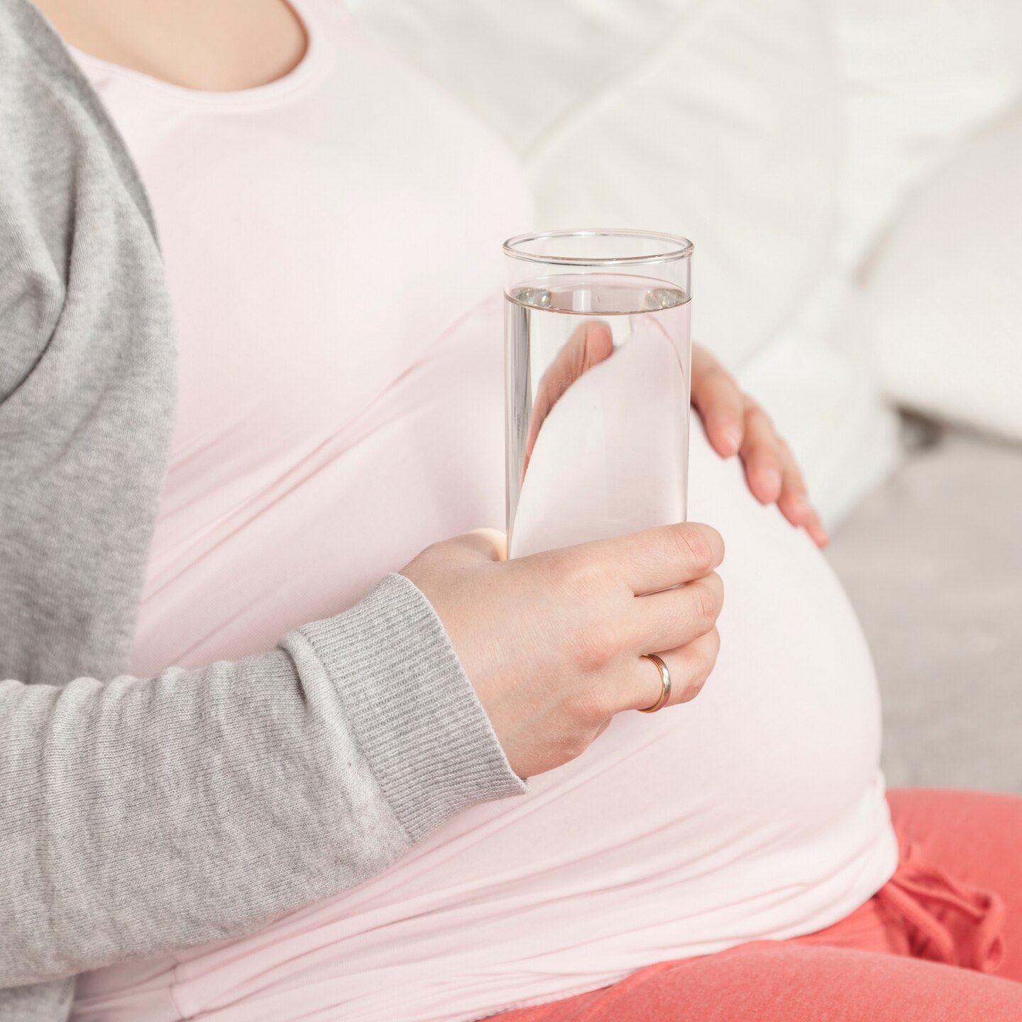 Schwangere hält Wasser in Hand