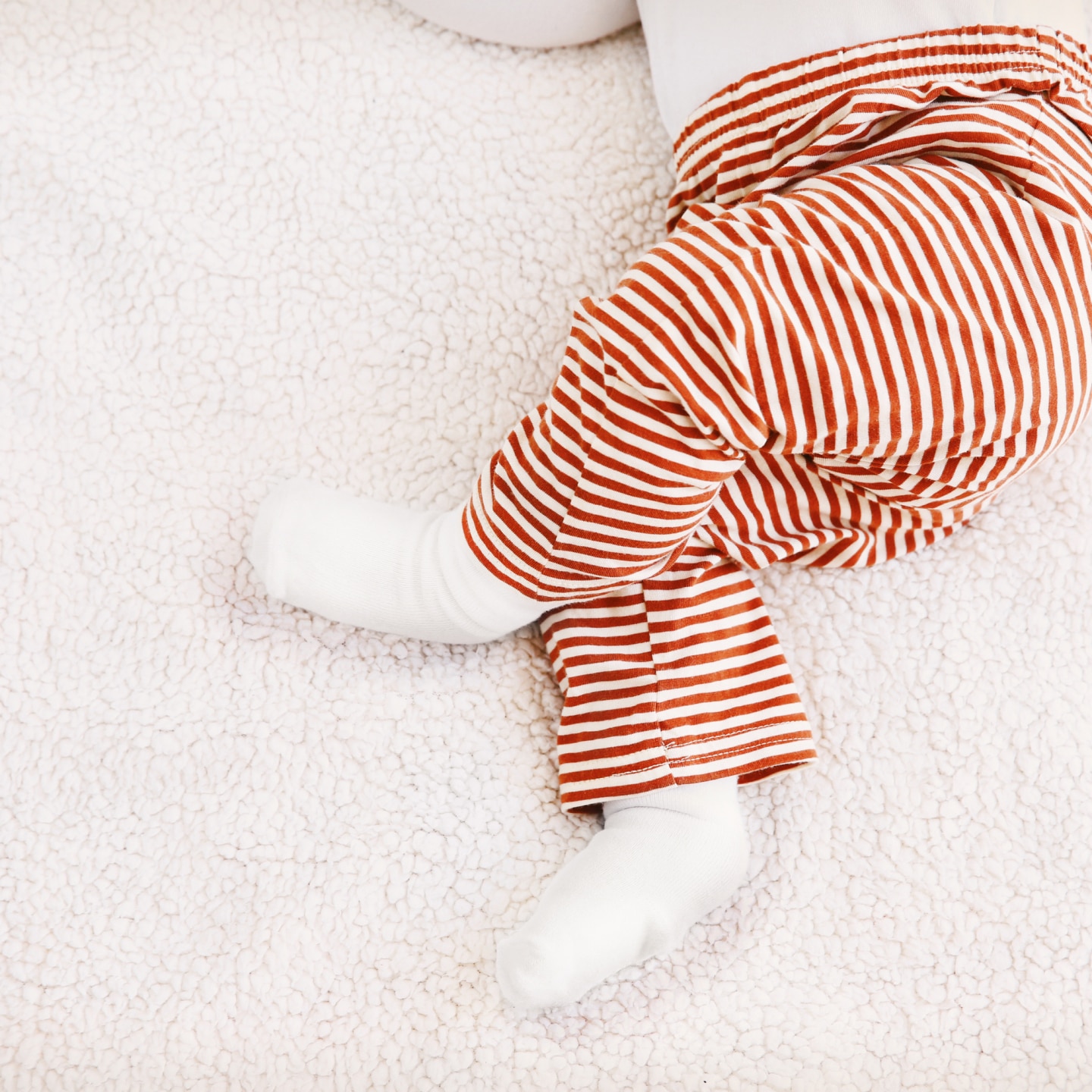 Cute little baby lying on plaid at home