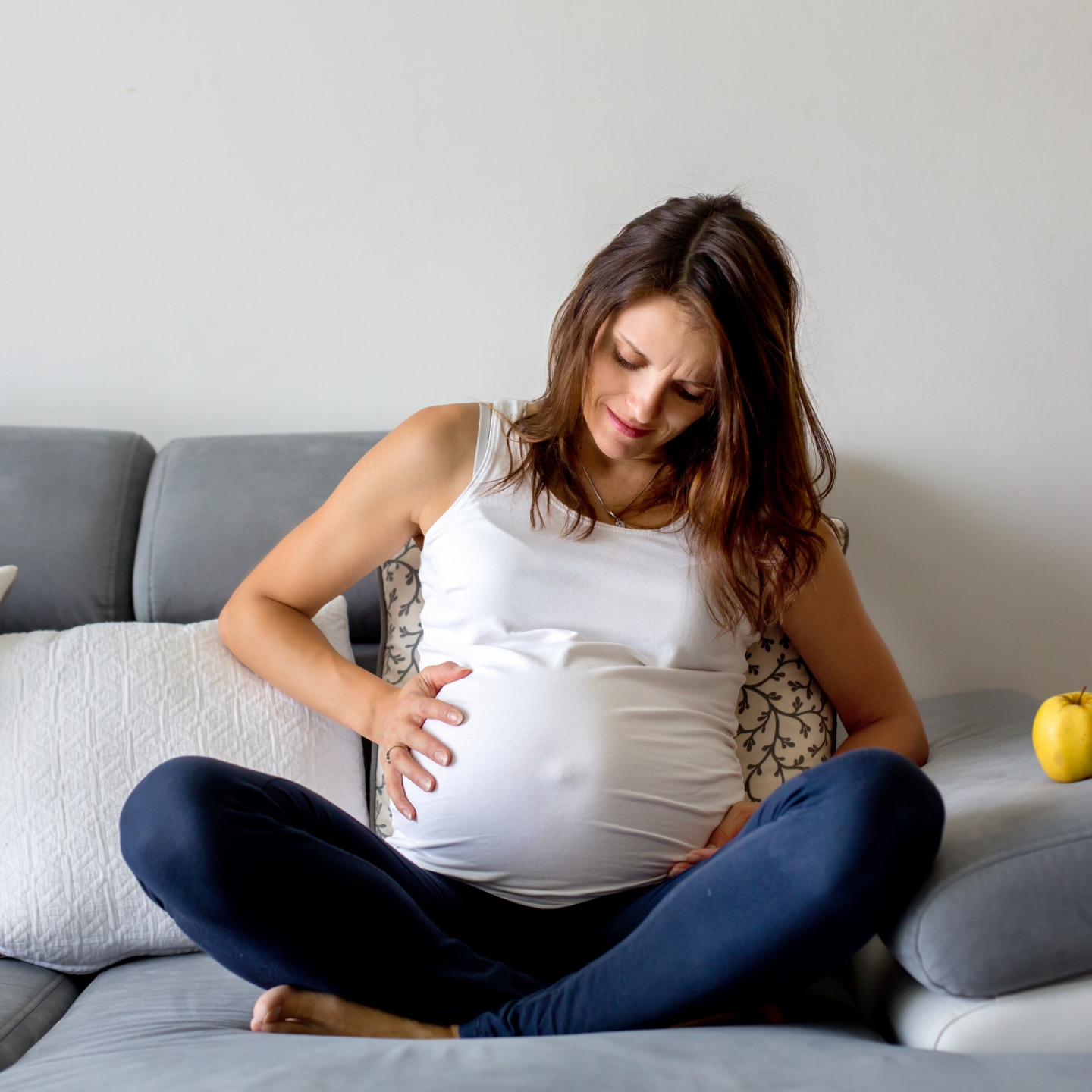 Schwangere fasst sich an den Bauch