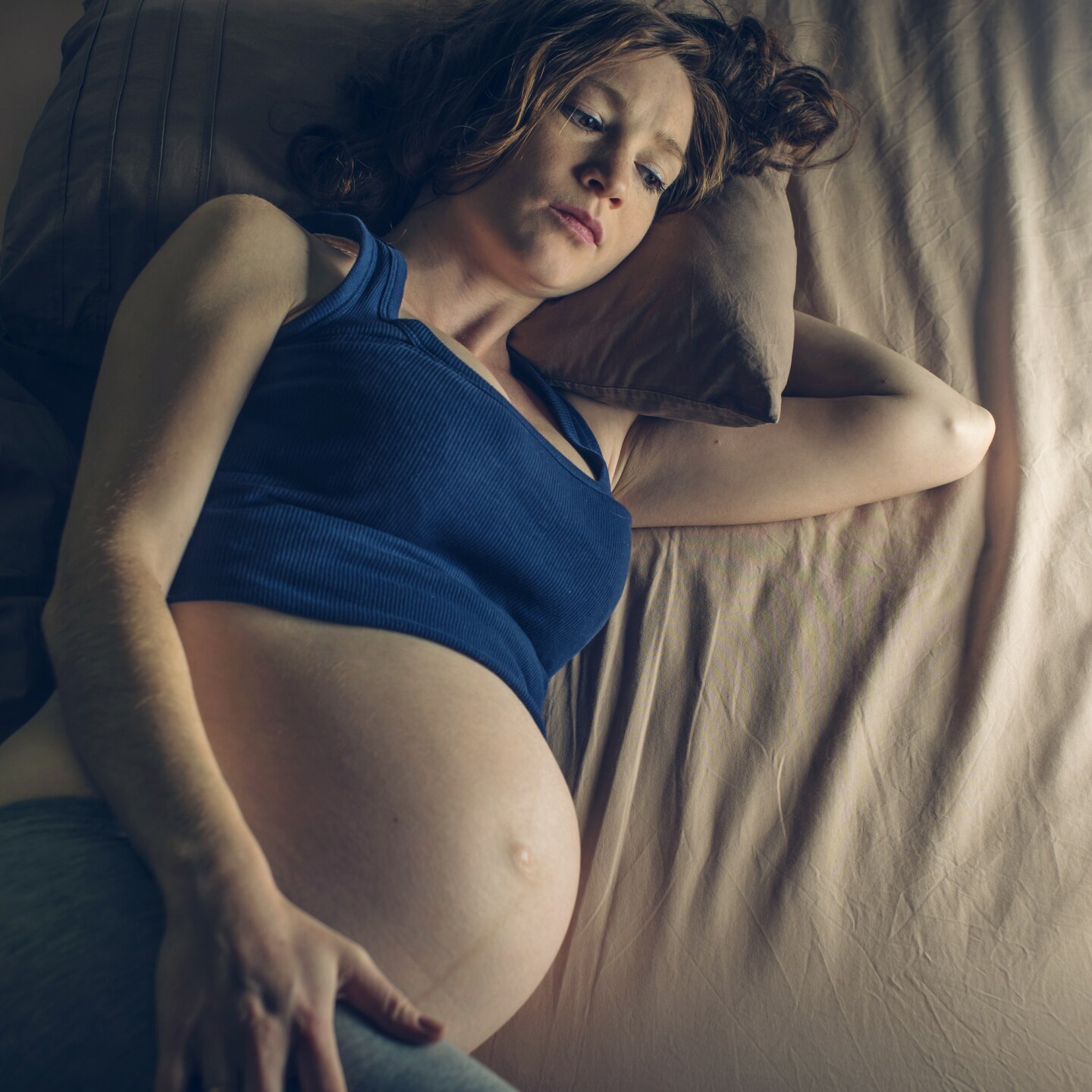 Schwangere liegt wach im Bett