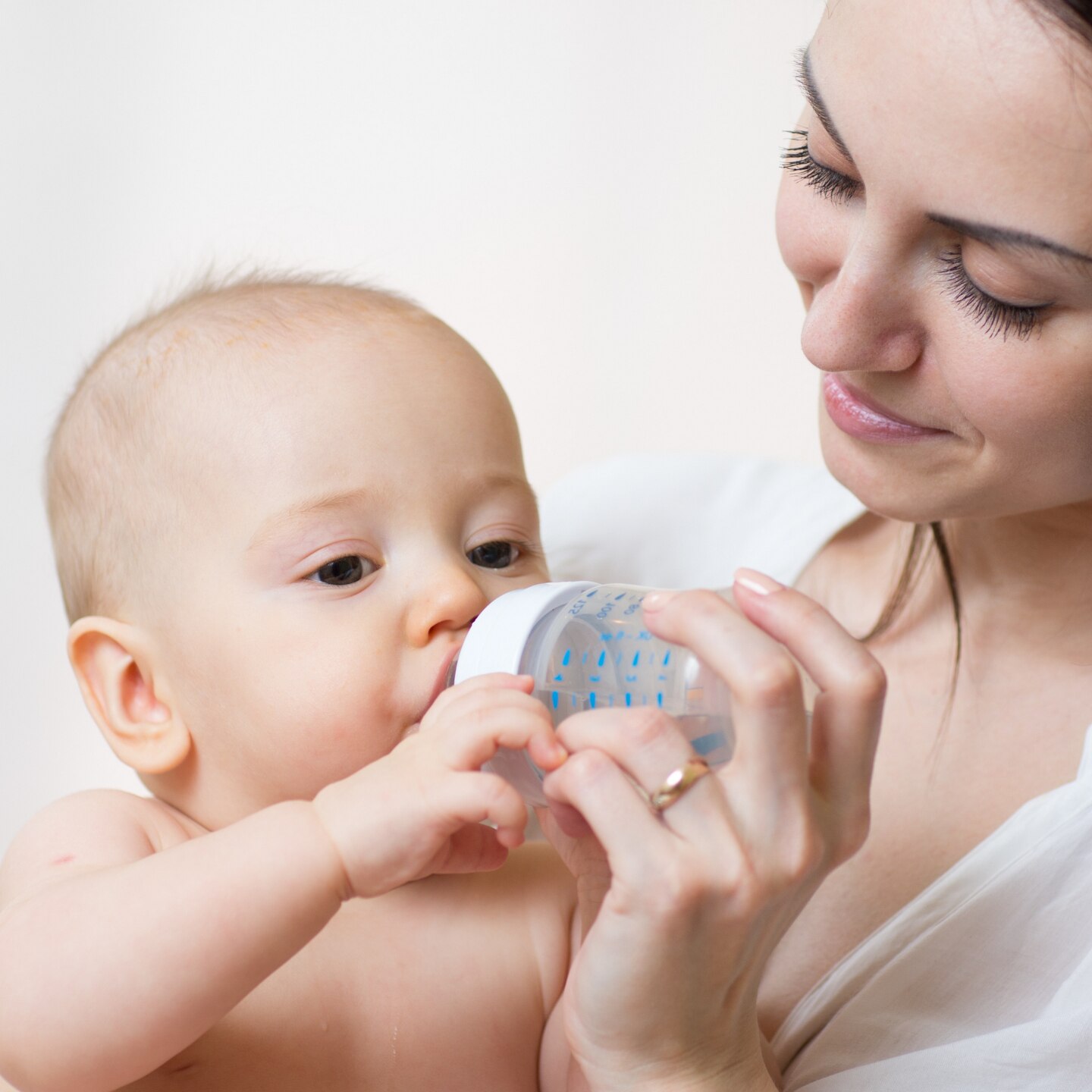 happy mother feeds her baby from bottle