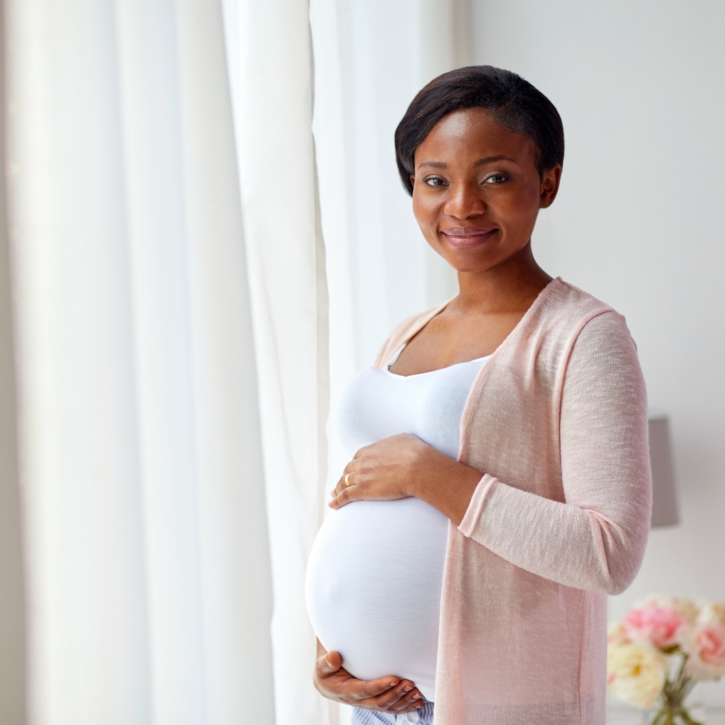 pregnant african american woman at home window