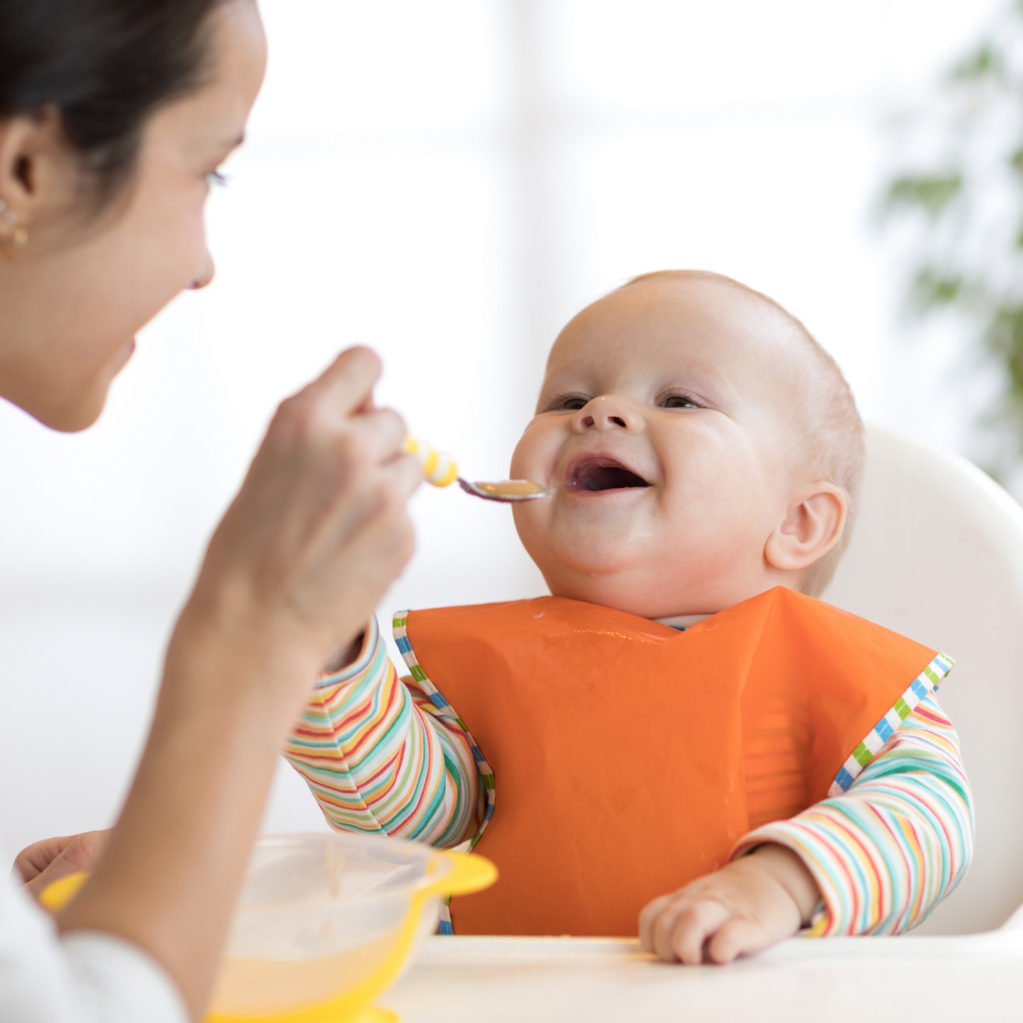 Mother feeding her baby with spoon