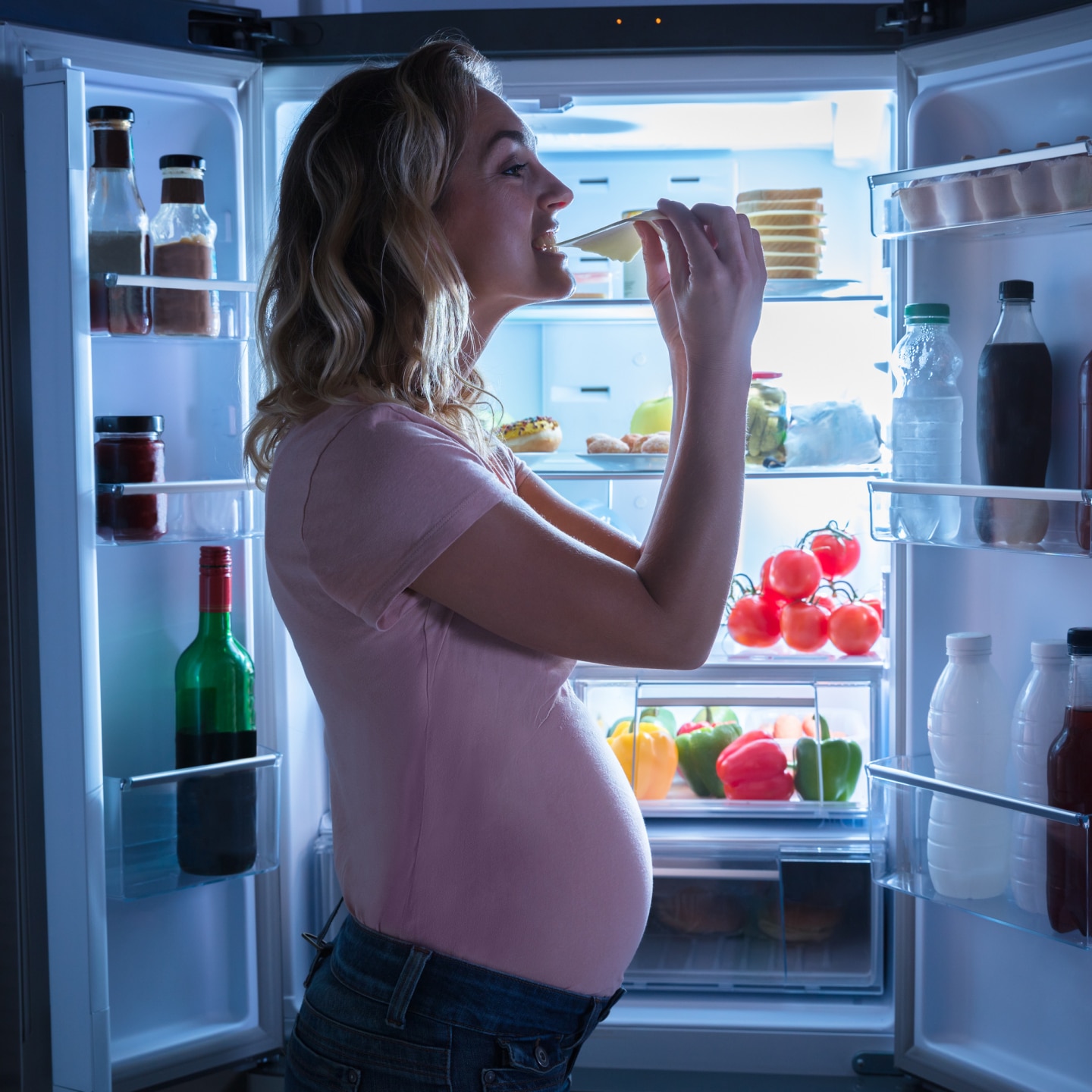 Pregnant Woman Eating Slice Of Cheese