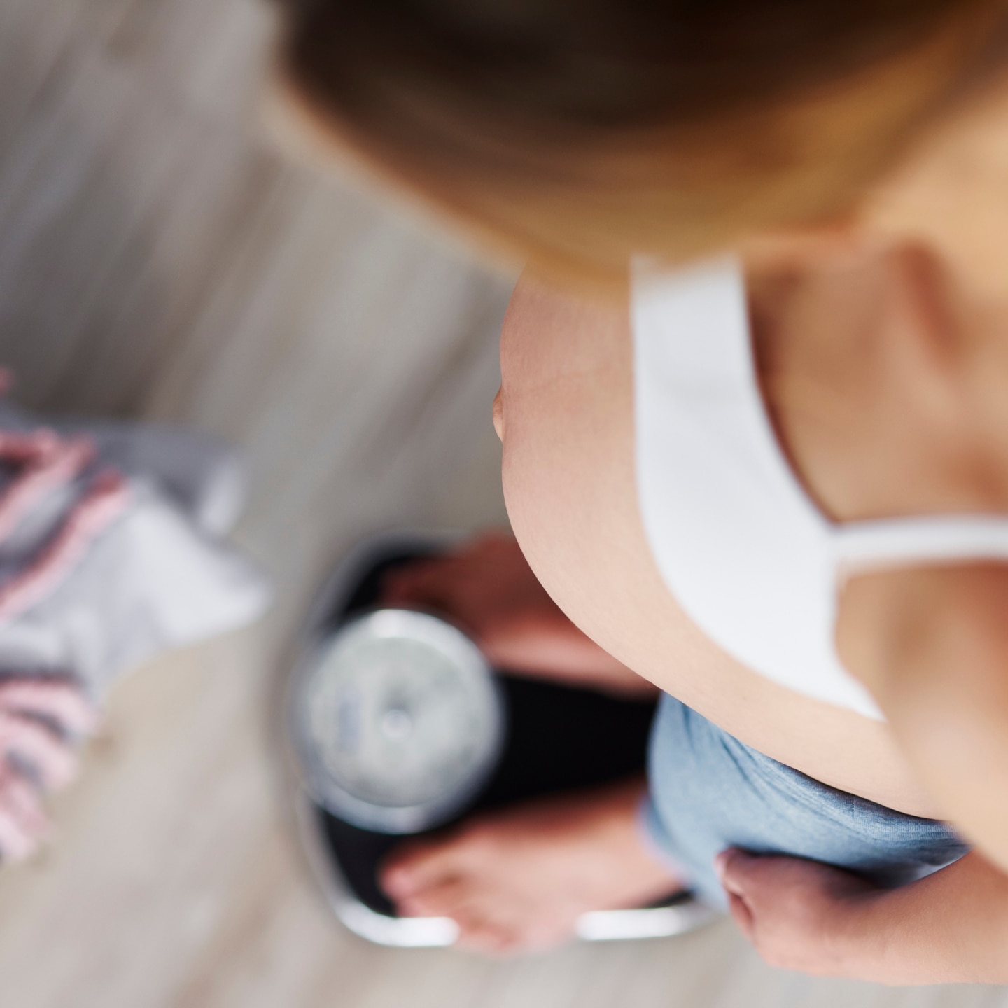 Schwangere steht auf der Waage