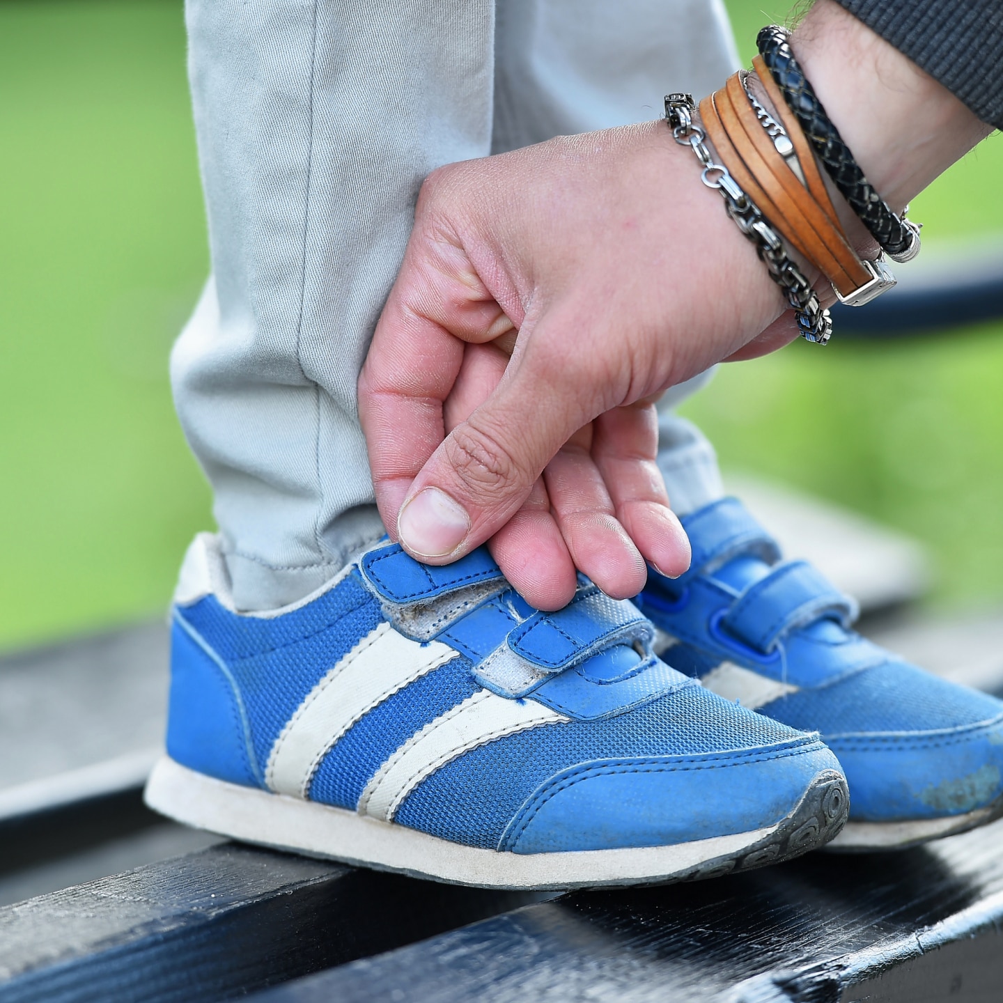 man tying velcro snickers on child
