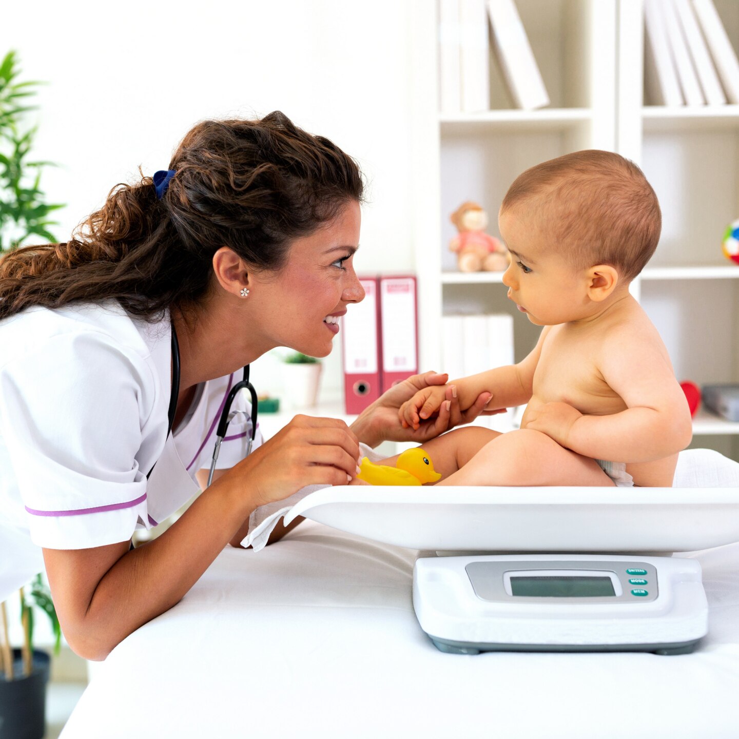 Baby beim Arzt auf der Waage 