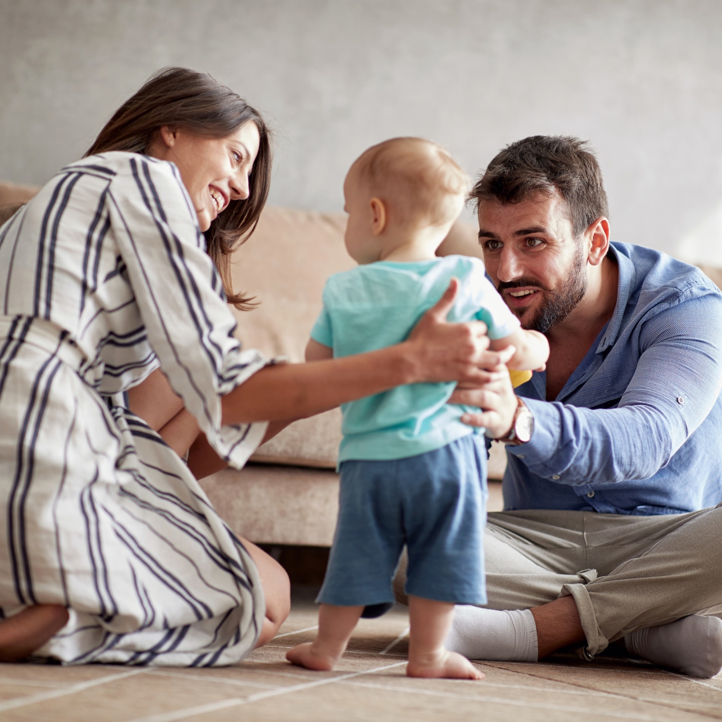 family is having fun playing with a baby at home