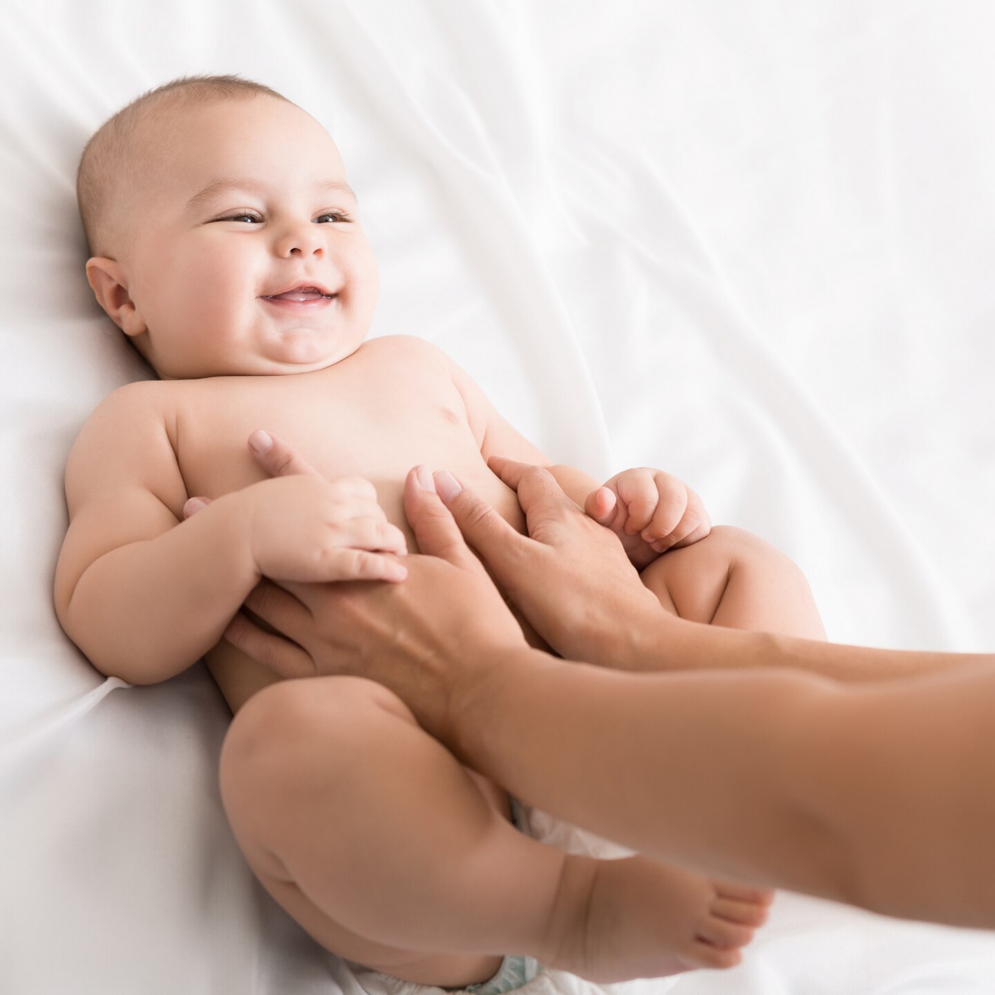 Masseur massaging tummy of baby during colic
