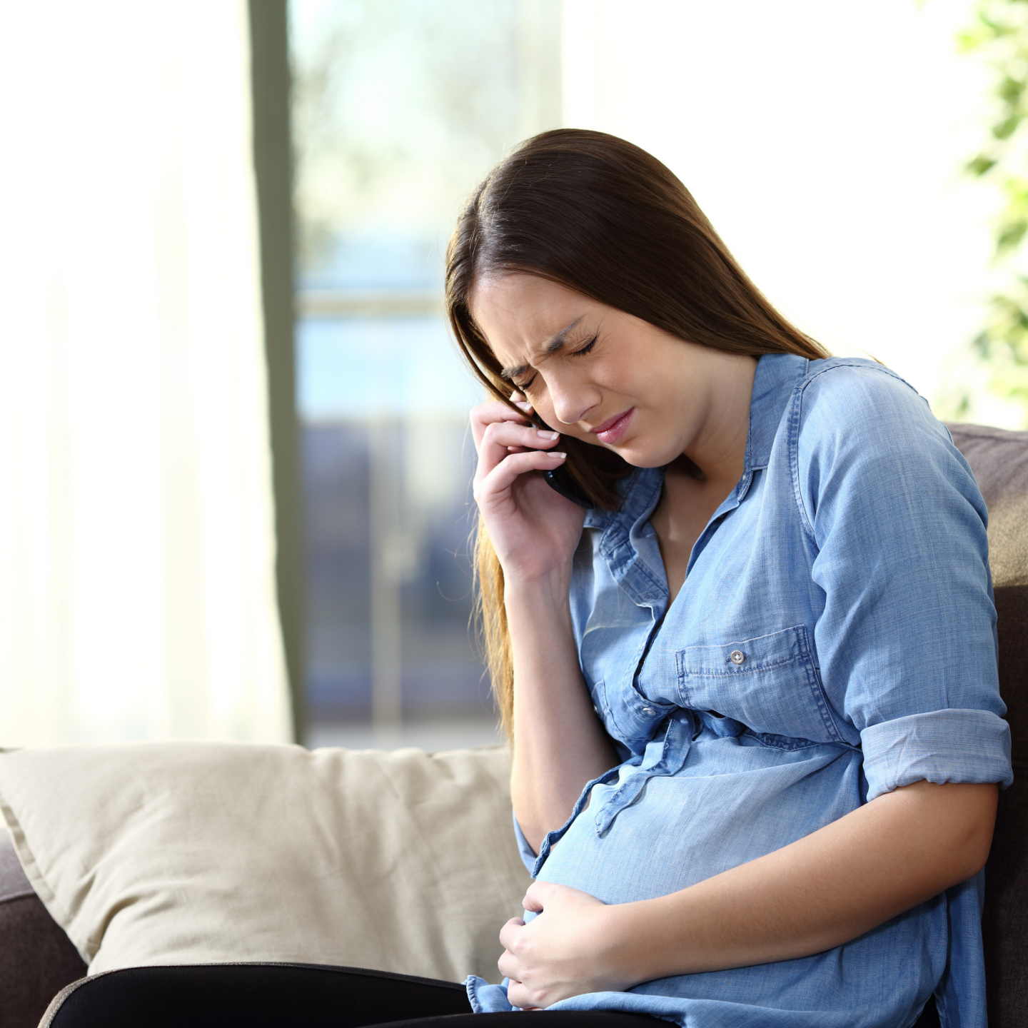 Schwangere telefoniert mit Schmerzen