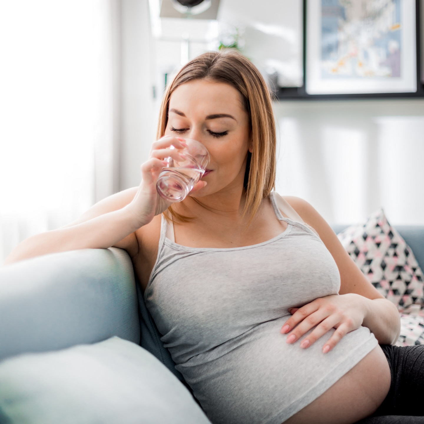 Schwangere trinkt Glas Wasser 