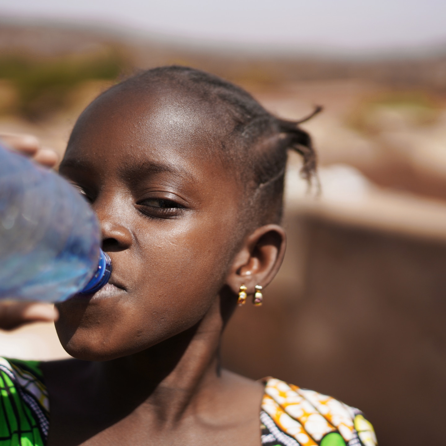 Kind trinkt Wasser aus der Flasche