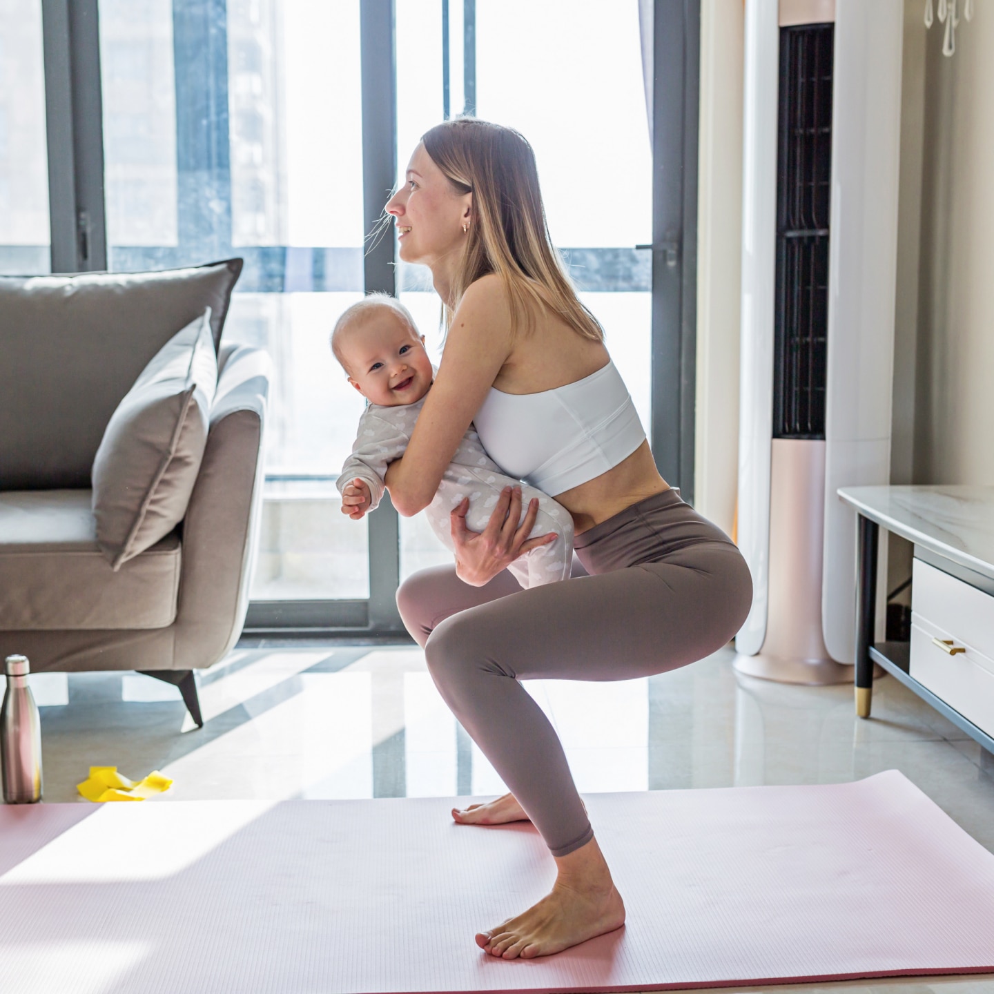 Mutter macht Sport mit Baby im Arm