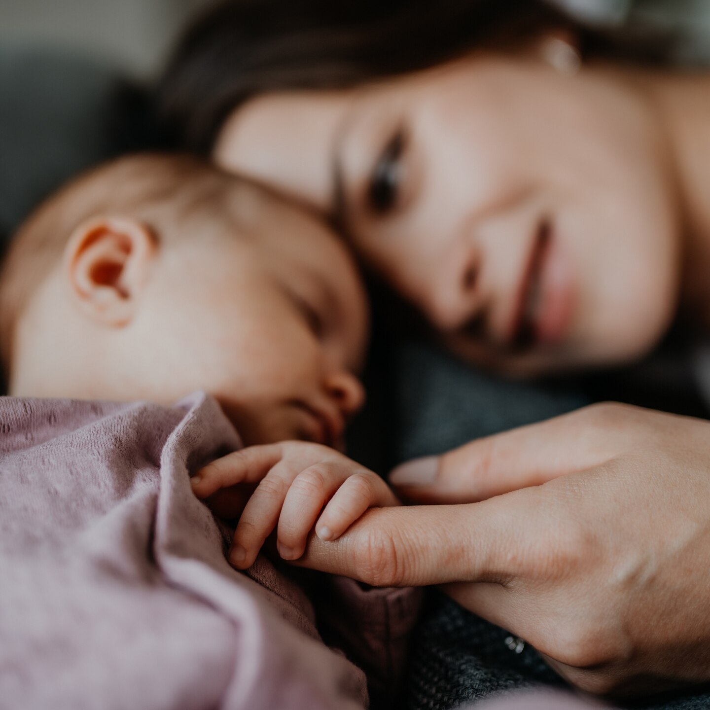 Happy young mother touching her newborn baby girl,