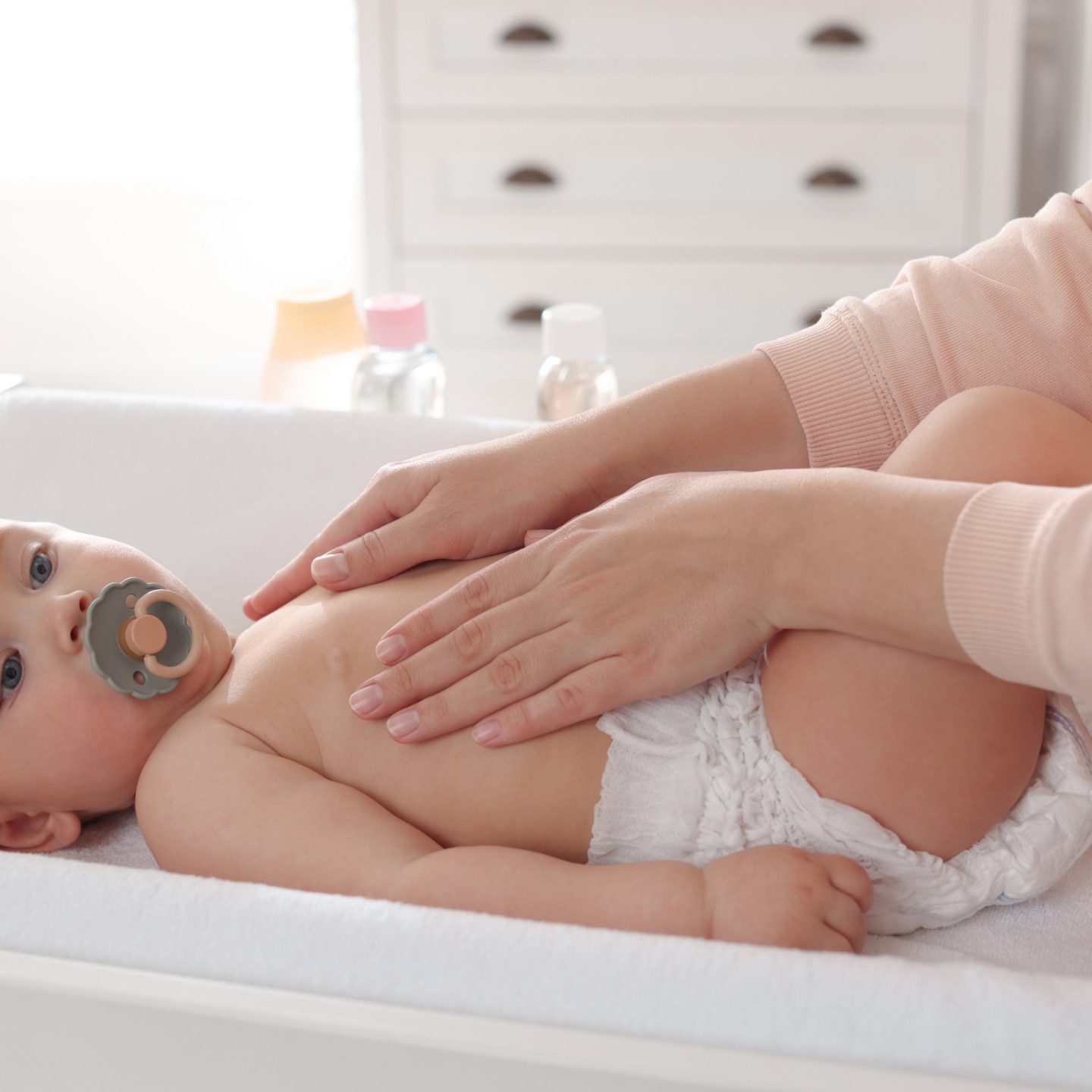 Mother massaging her cute baby