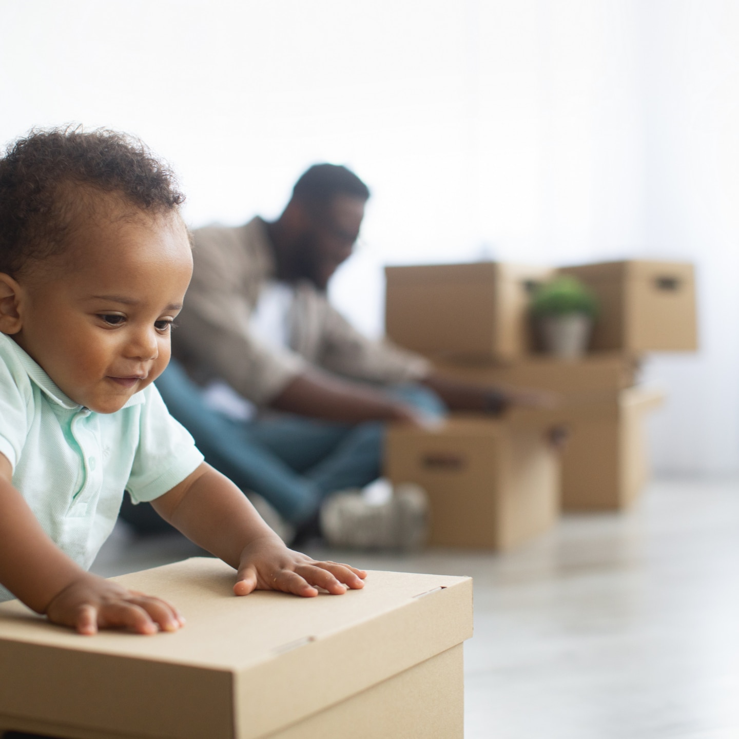 baby lehnt sich auf eine Umzugsbox
