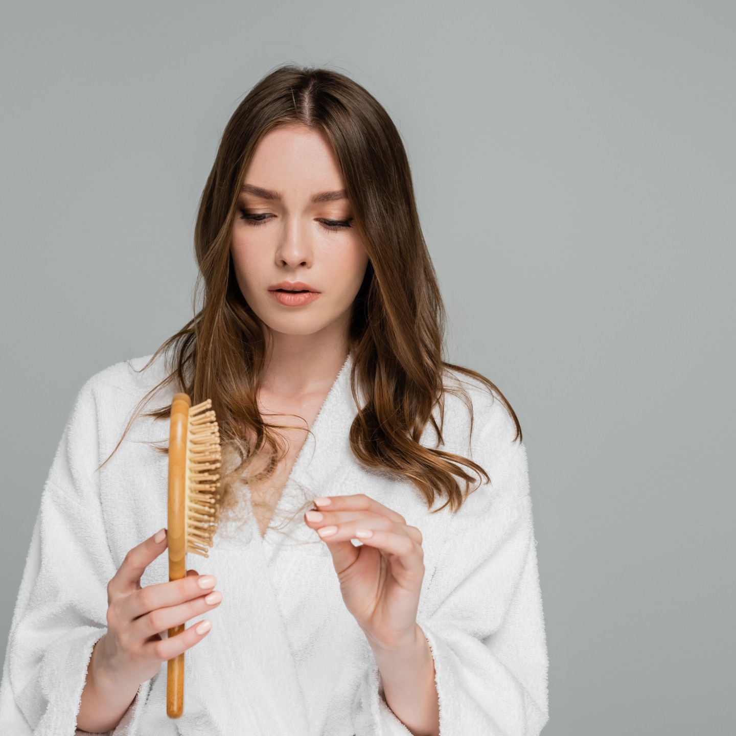 stressed young woman holding wooden hair brush