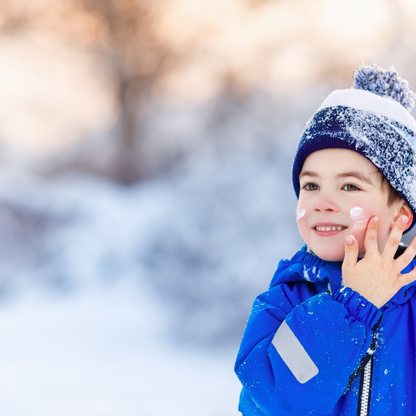 Junge cremt sich in der Kälte ein