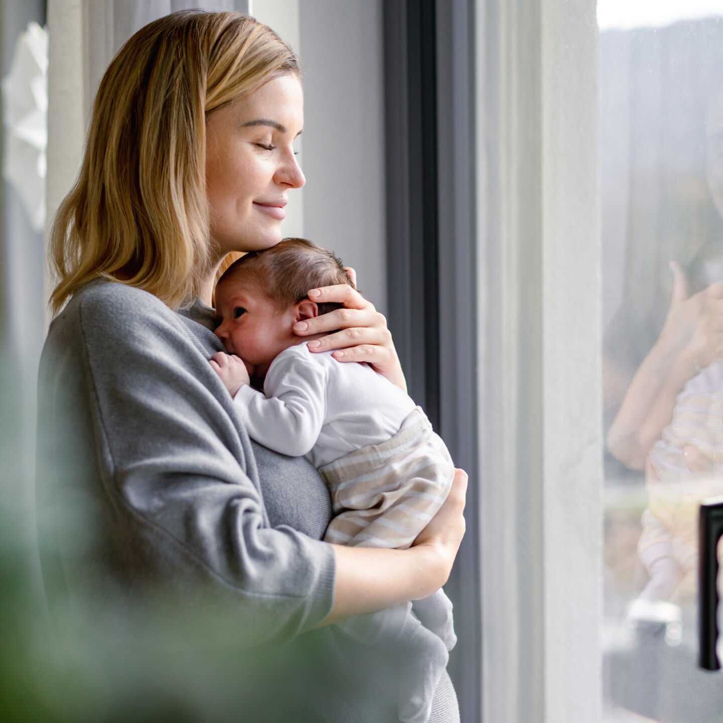 Loving mother hugs her little baby at home