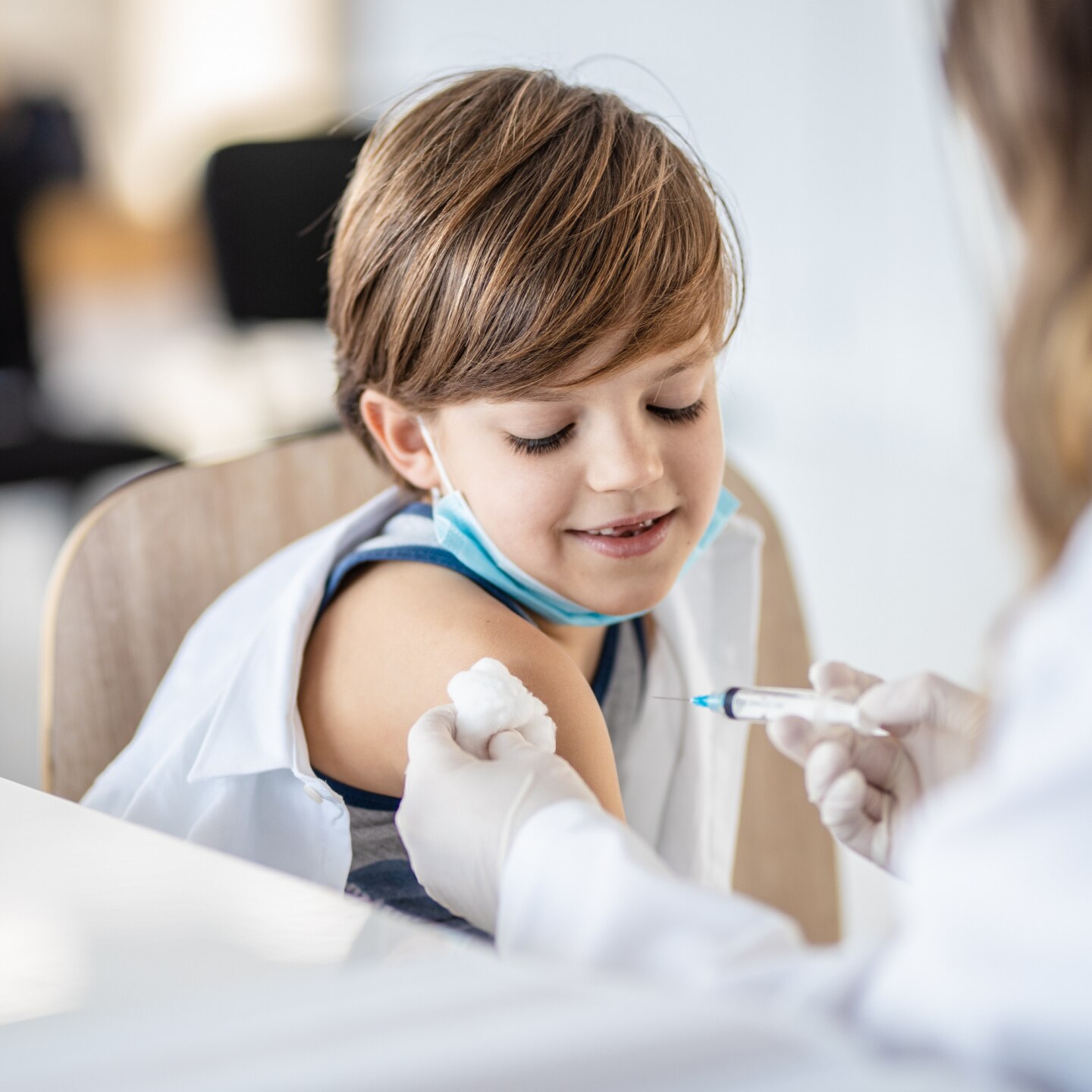 Junge wird geimpft beim Arzt
