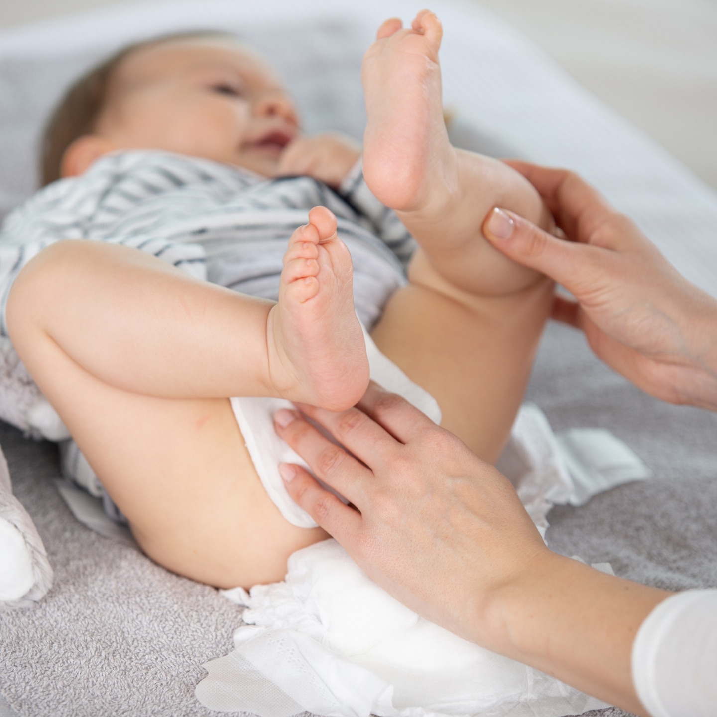 mother cleaning up her baby buttocks with wet hankies