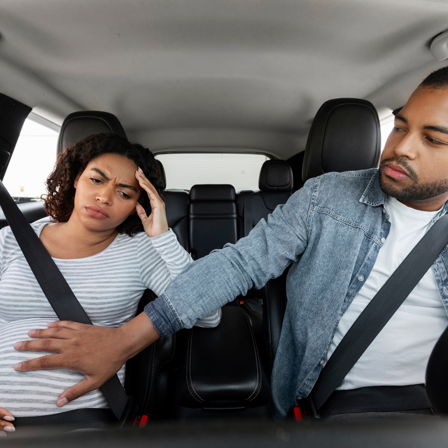 Young pregnant african american woman feeling pain in car