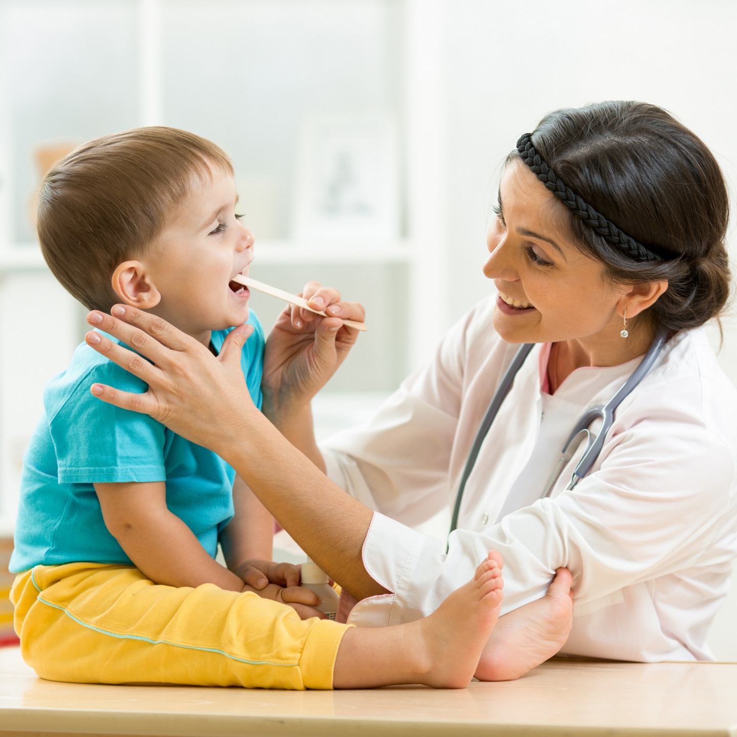 doctor examining little boy isolated on white background