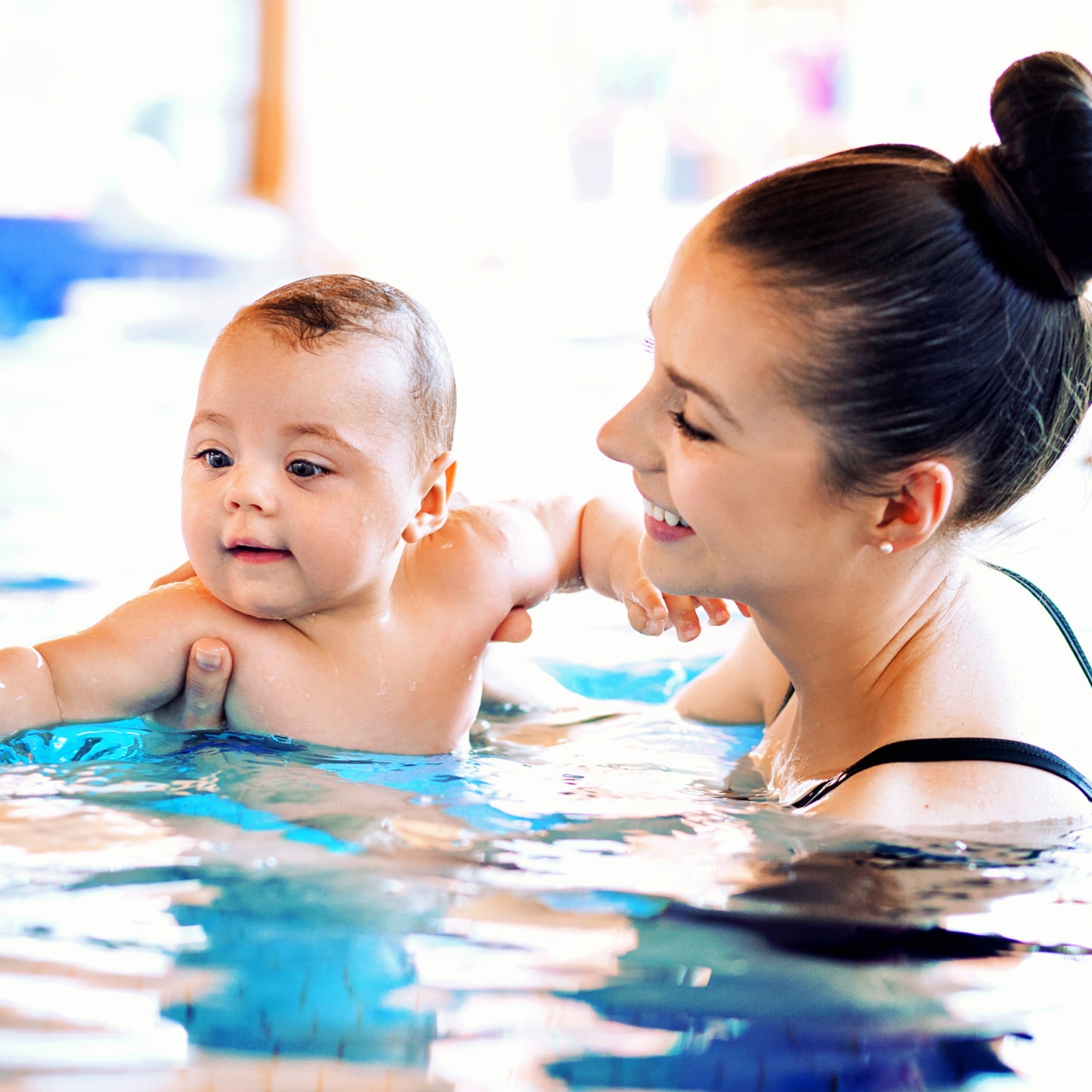 Mother swimming her cute baby