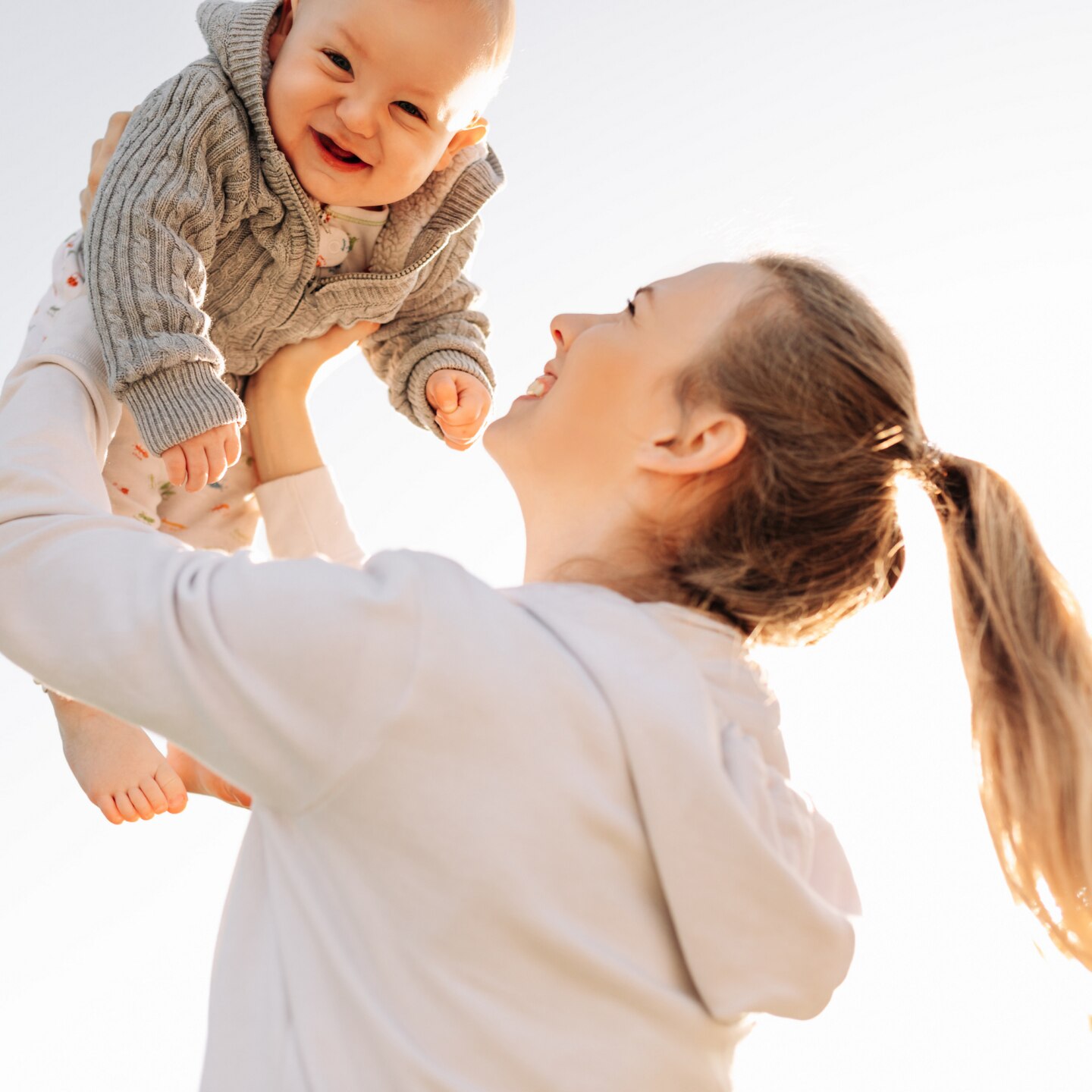 mama hält baby hoch in die luft