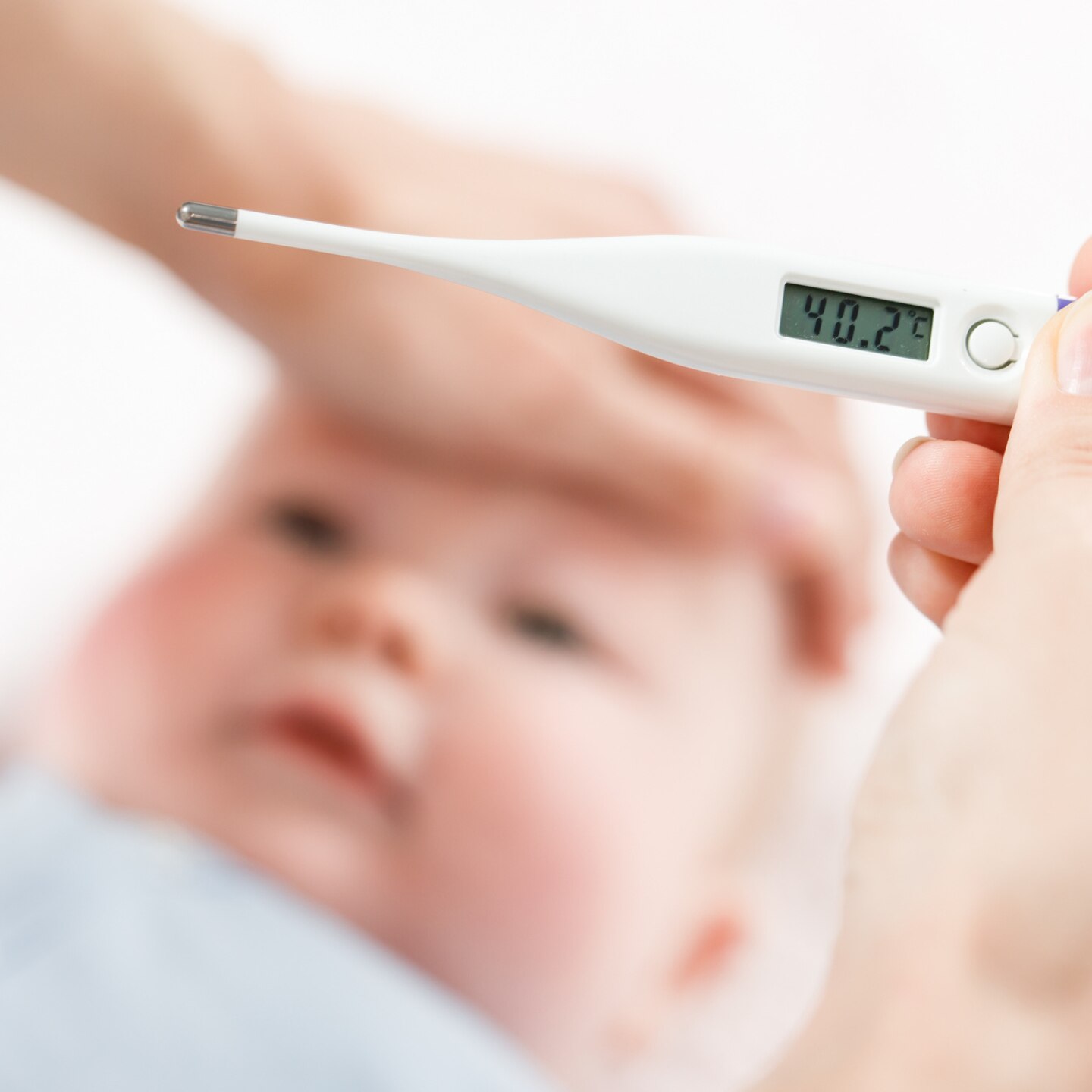 mutter misst temperatur  mit fieberthermometer bei baby