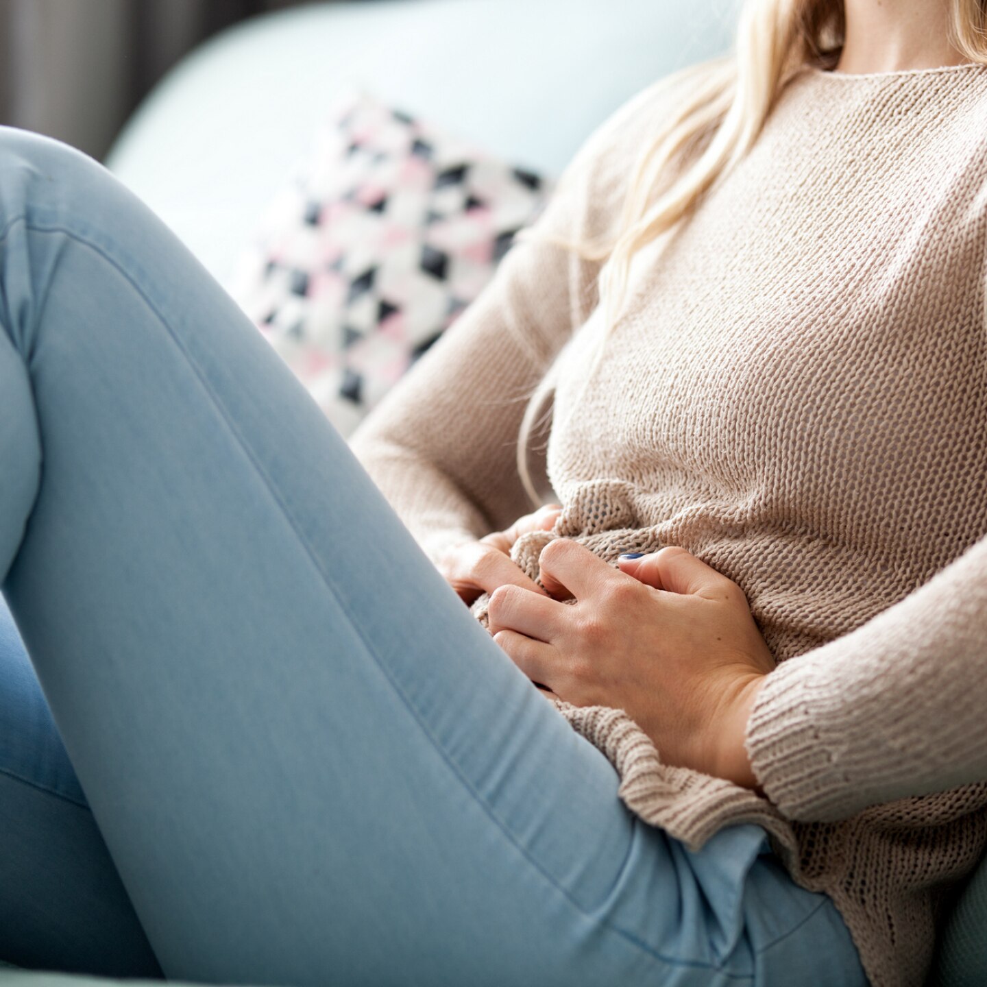 frau hält sich den unterbauch vor schmerzen 